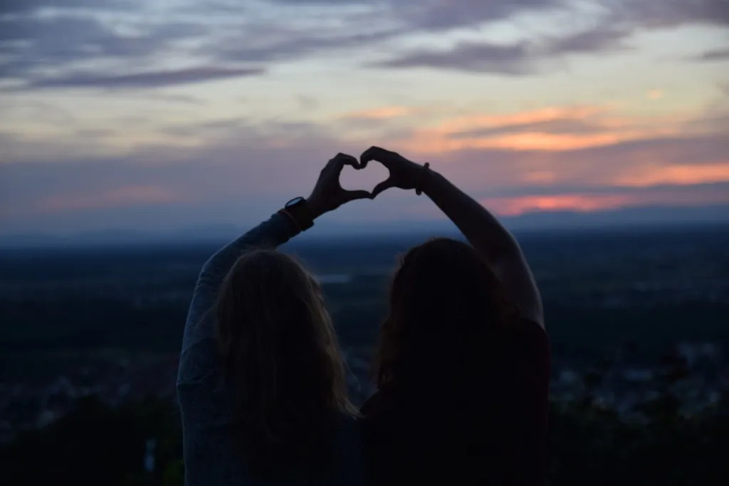 deux femmes faisant un coeur avec leur main