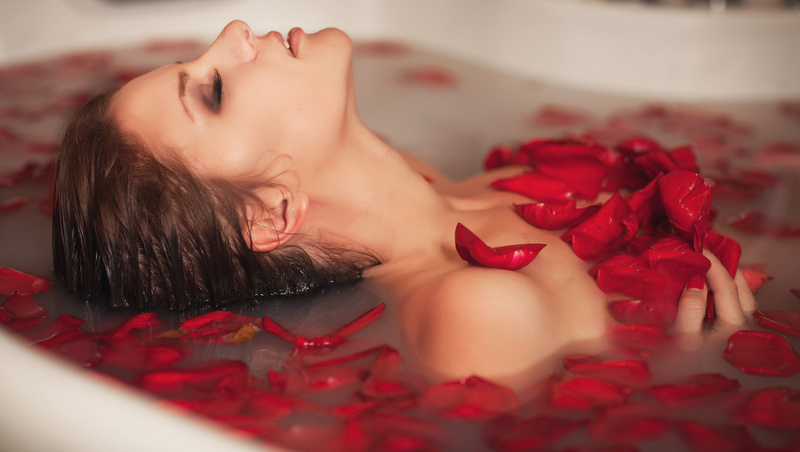 femme dans un bain de pétales de rose