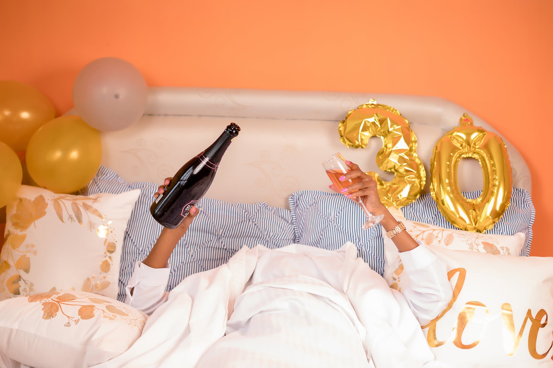 femme dans le lit avec une bouteille de champagne