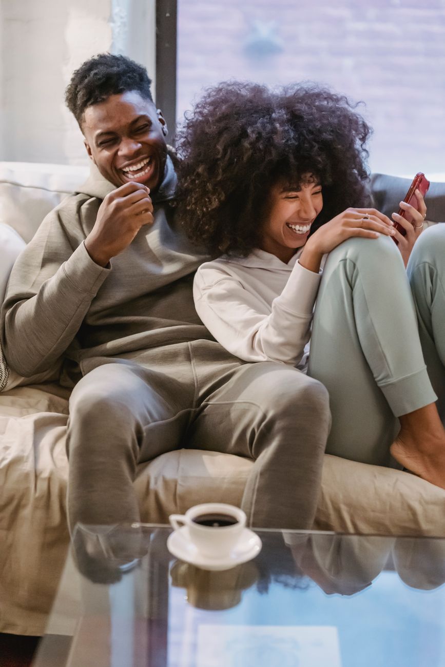 couple qui rigole sur le canapé